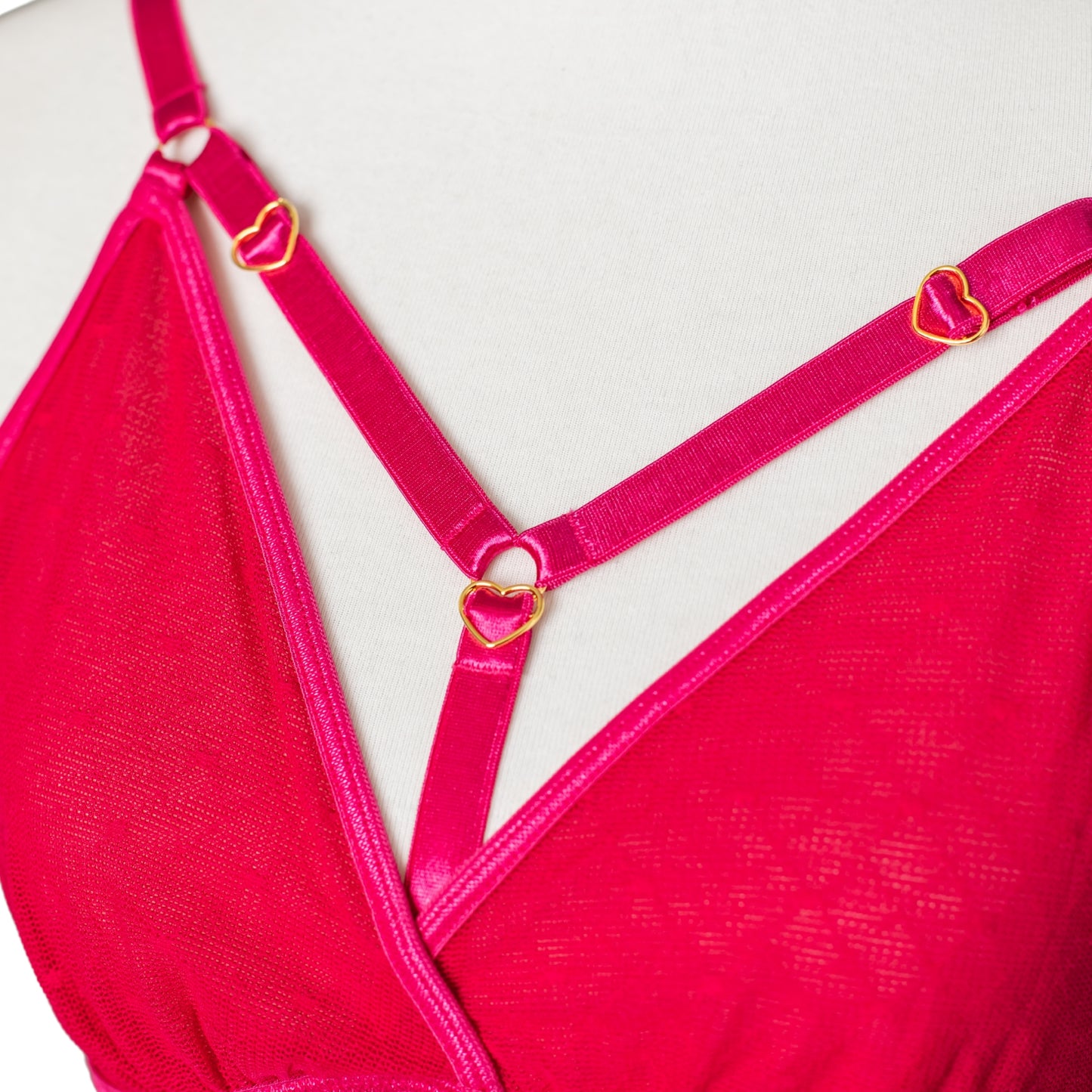 Close-up of gold heart details on hot pink bralette