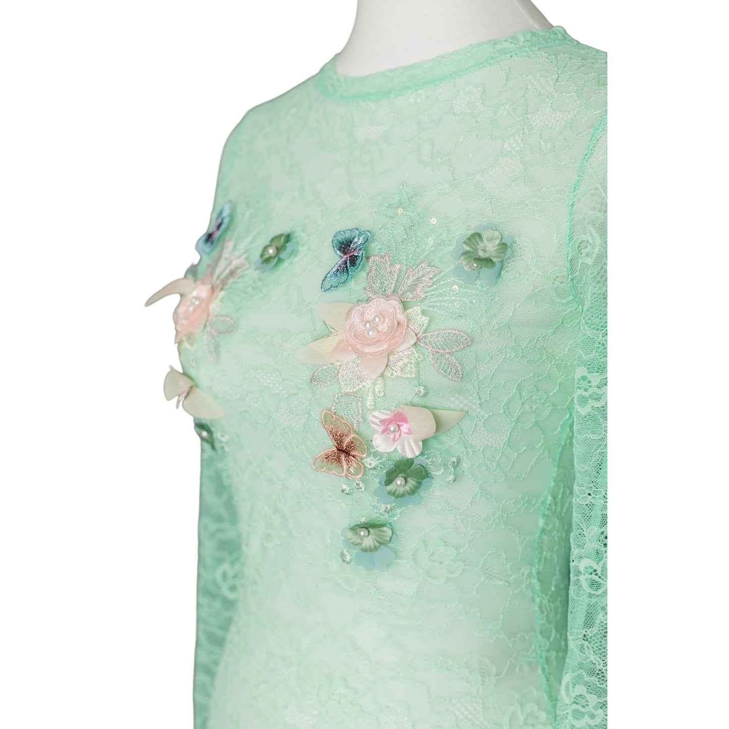Close-up of flower and butterfly details on mint-green lace bodysuit