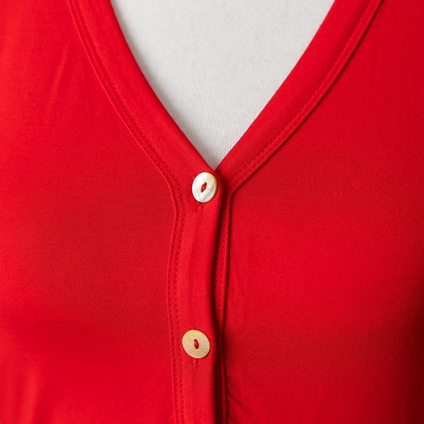 Close-up of mother-of-pearl buttons on red modal onesie pajamas