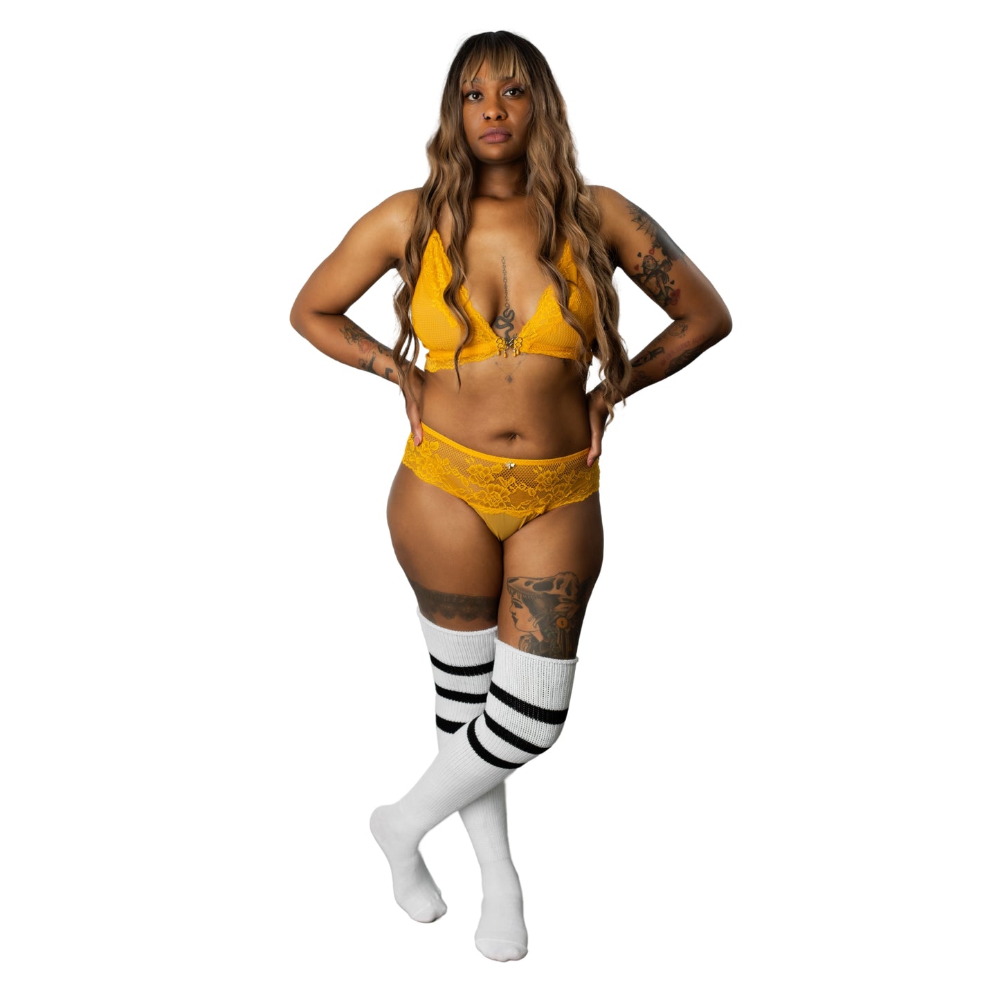 Full-body photo of woman wearing yellow lace bra and panty set with white thigh-high socks