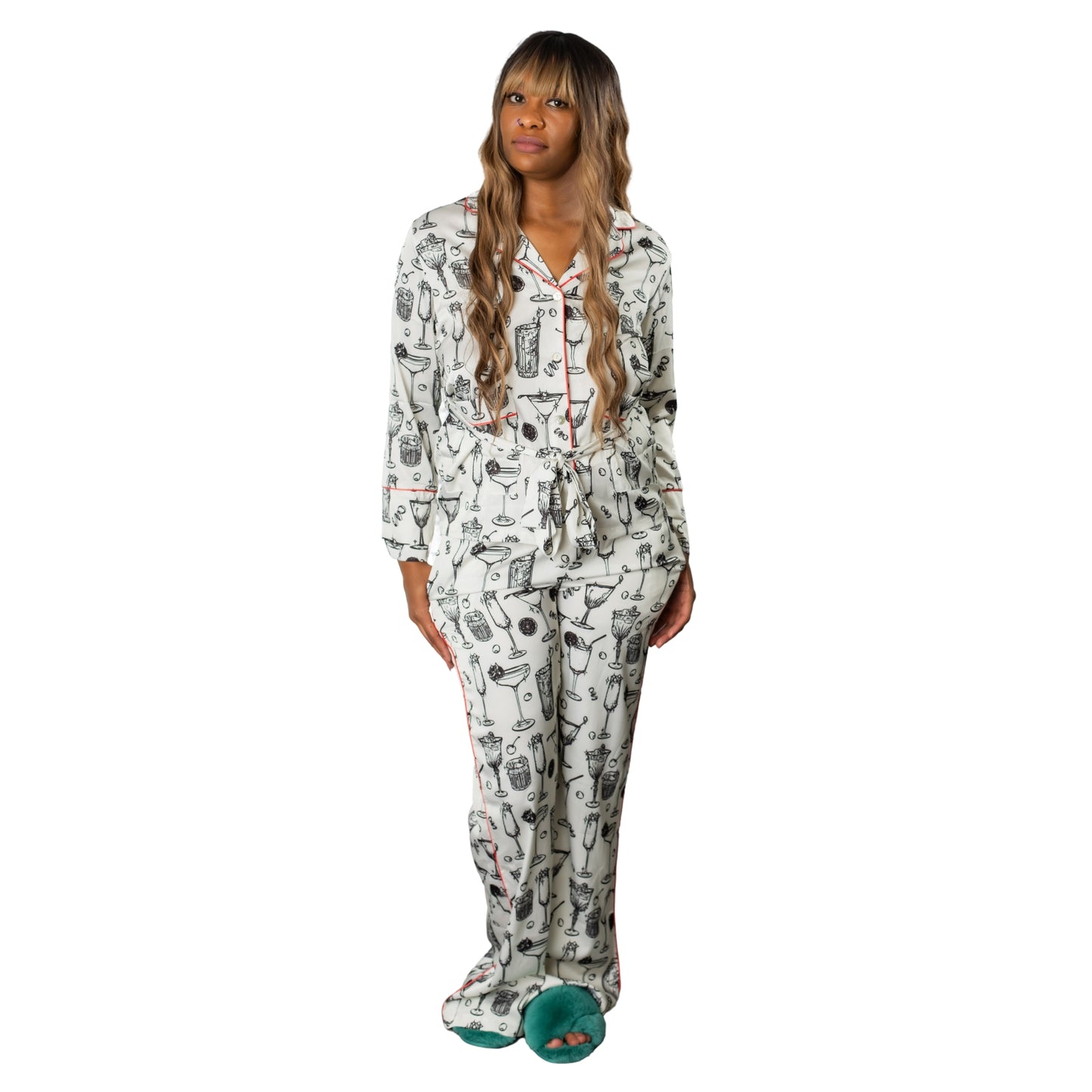 Woman standing with her hands in the pockets of her satin, cocktail-printed pajamas