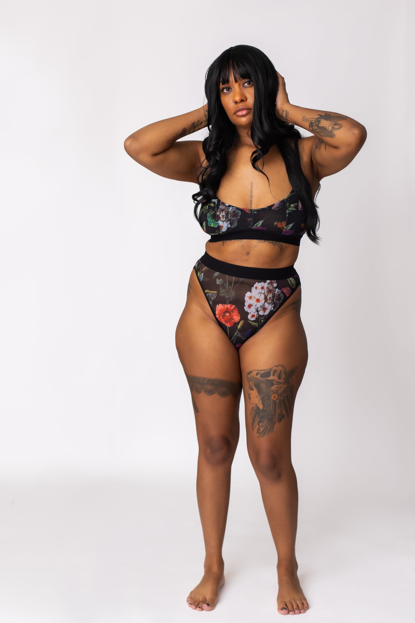Woman wearing a black floral mesh bra and high-waist, high-cut leg panty set