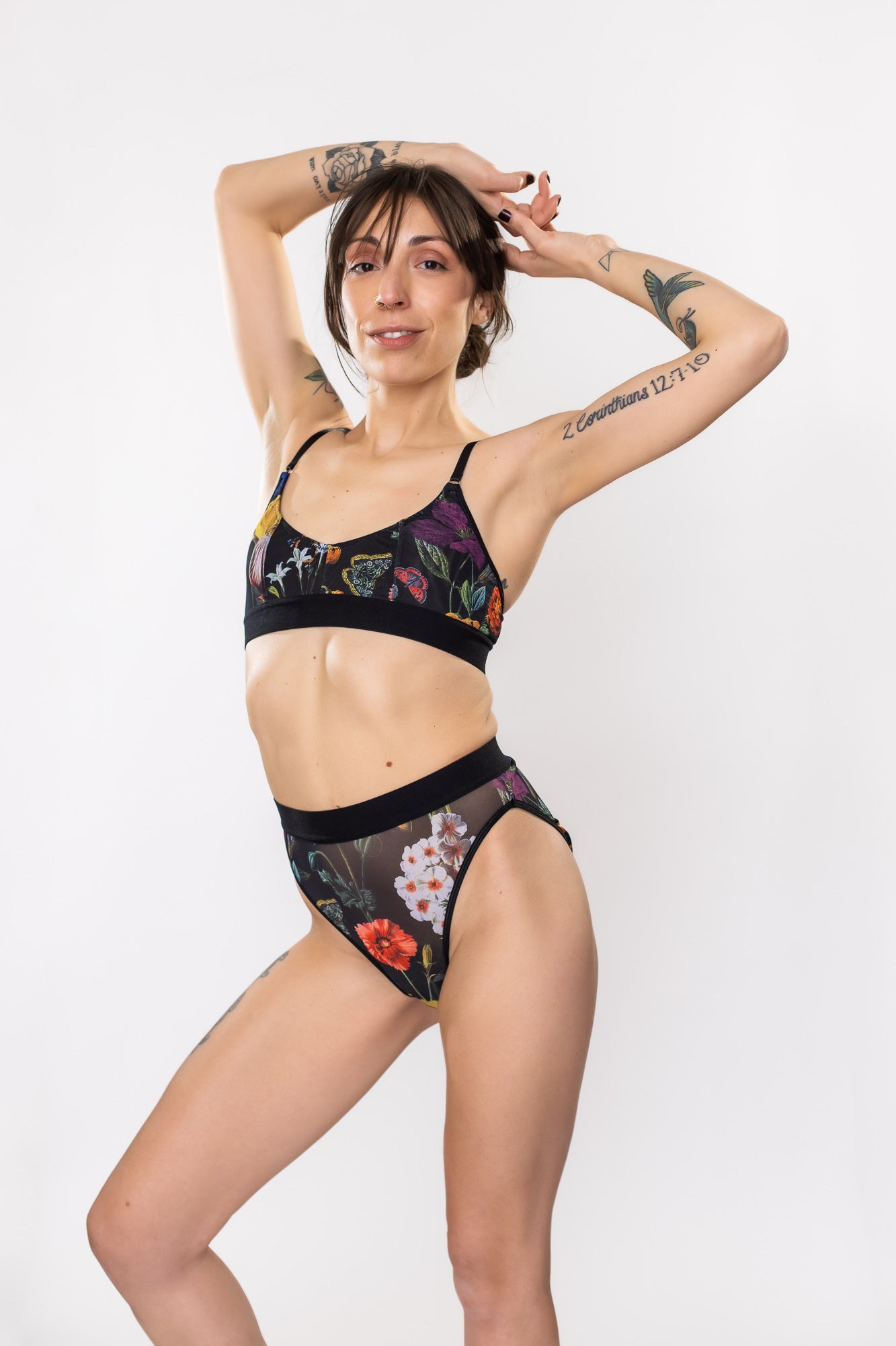 Woman posing in a black floral mesh bra and panty set