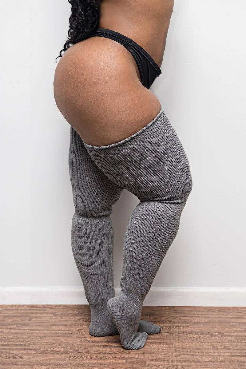 Side view on woman wearing plus-size gray knit thigh-high socks
