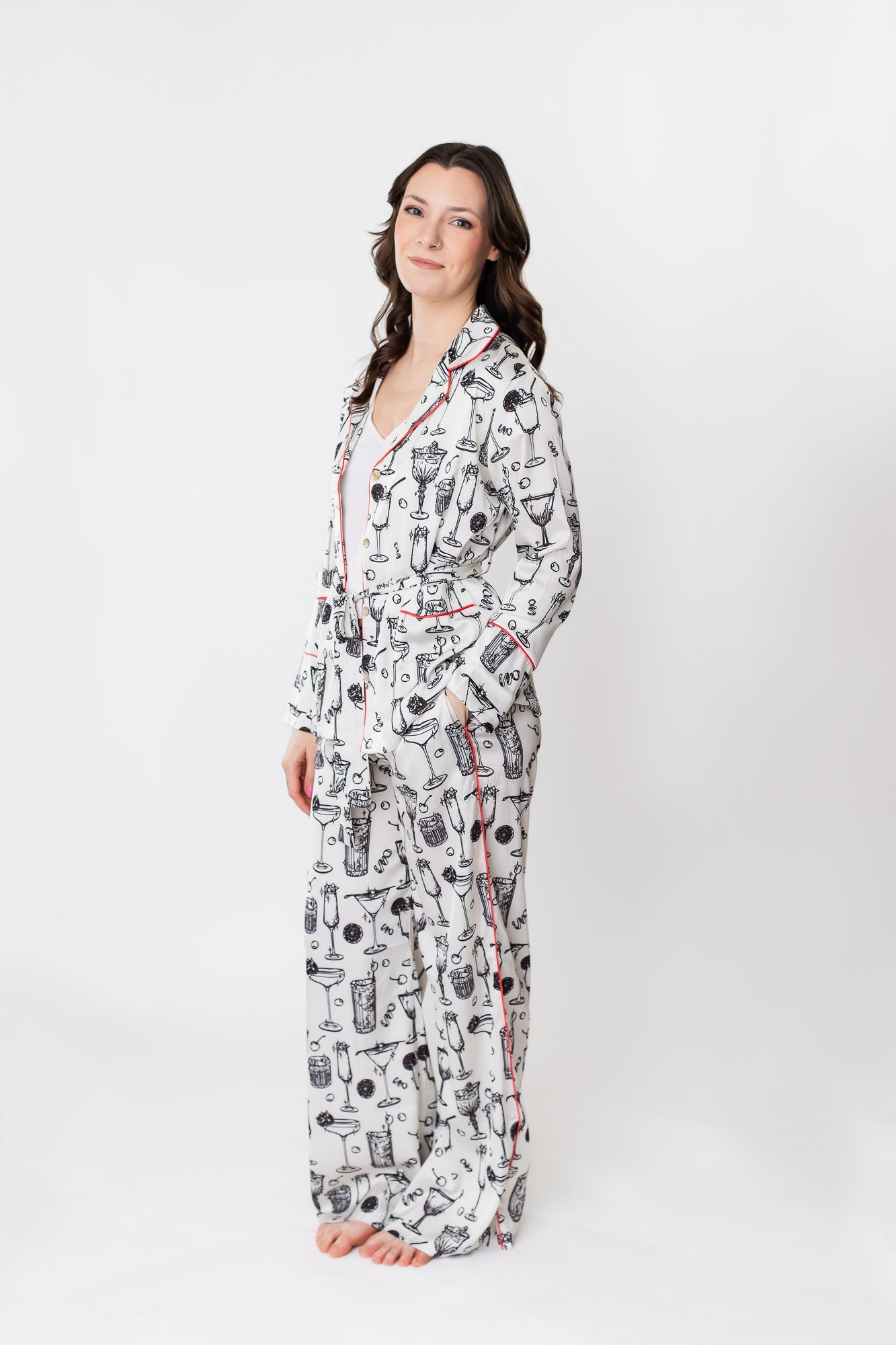 White woman posing in satin pajamas with a cocktail print
