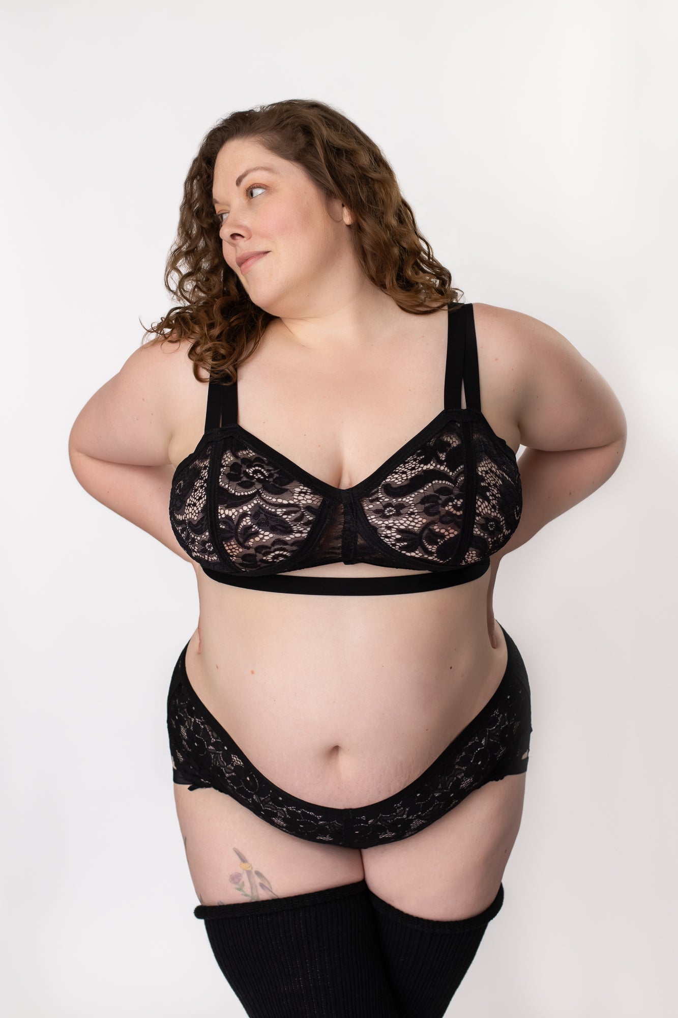 Woman standing a a black lace bra and panty set