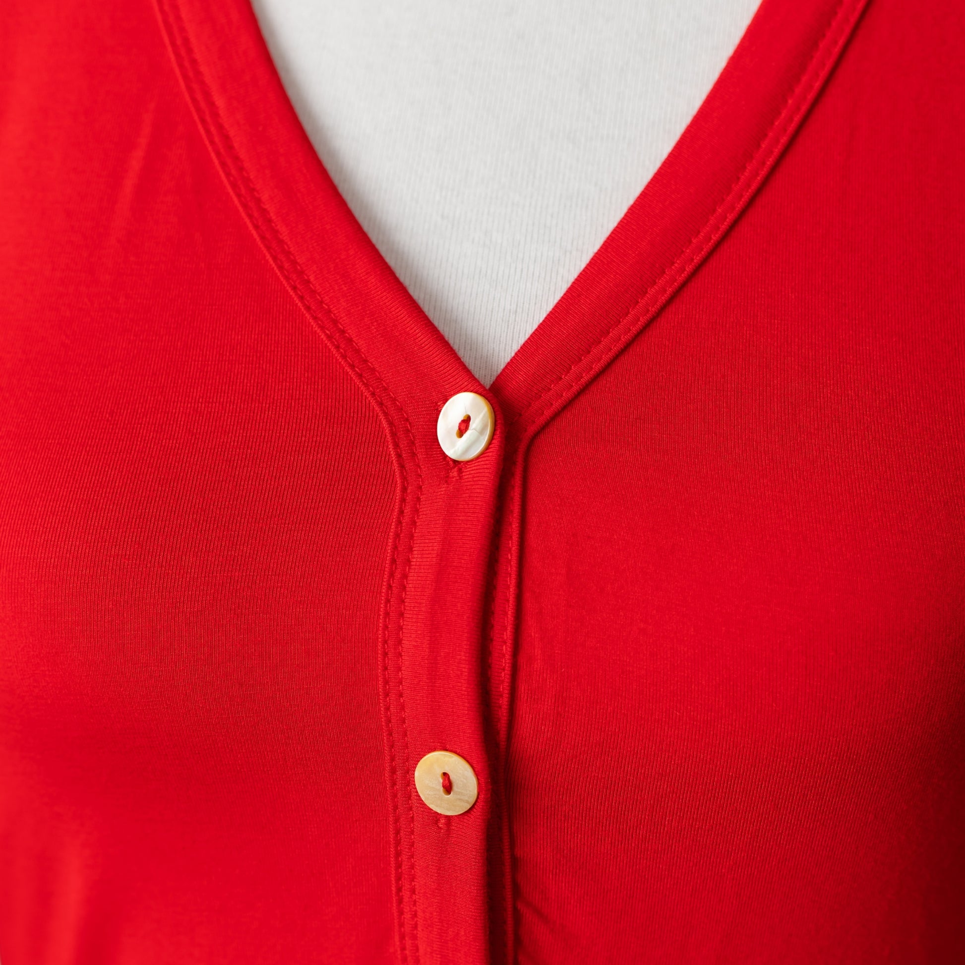 Close-up of mother-of-pearl buttons on red modal onesie pajamas