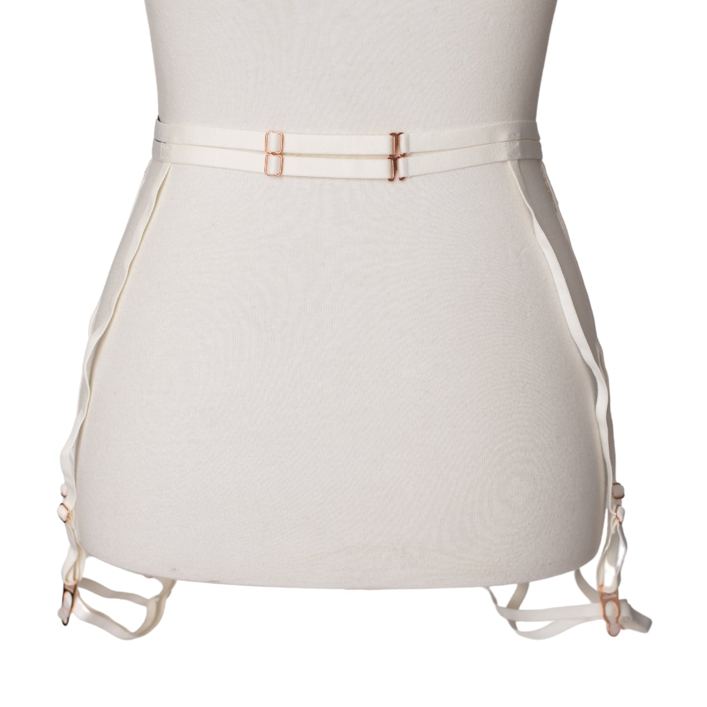 Back view of a white lace garter belt and leg garters with rose gold hardware