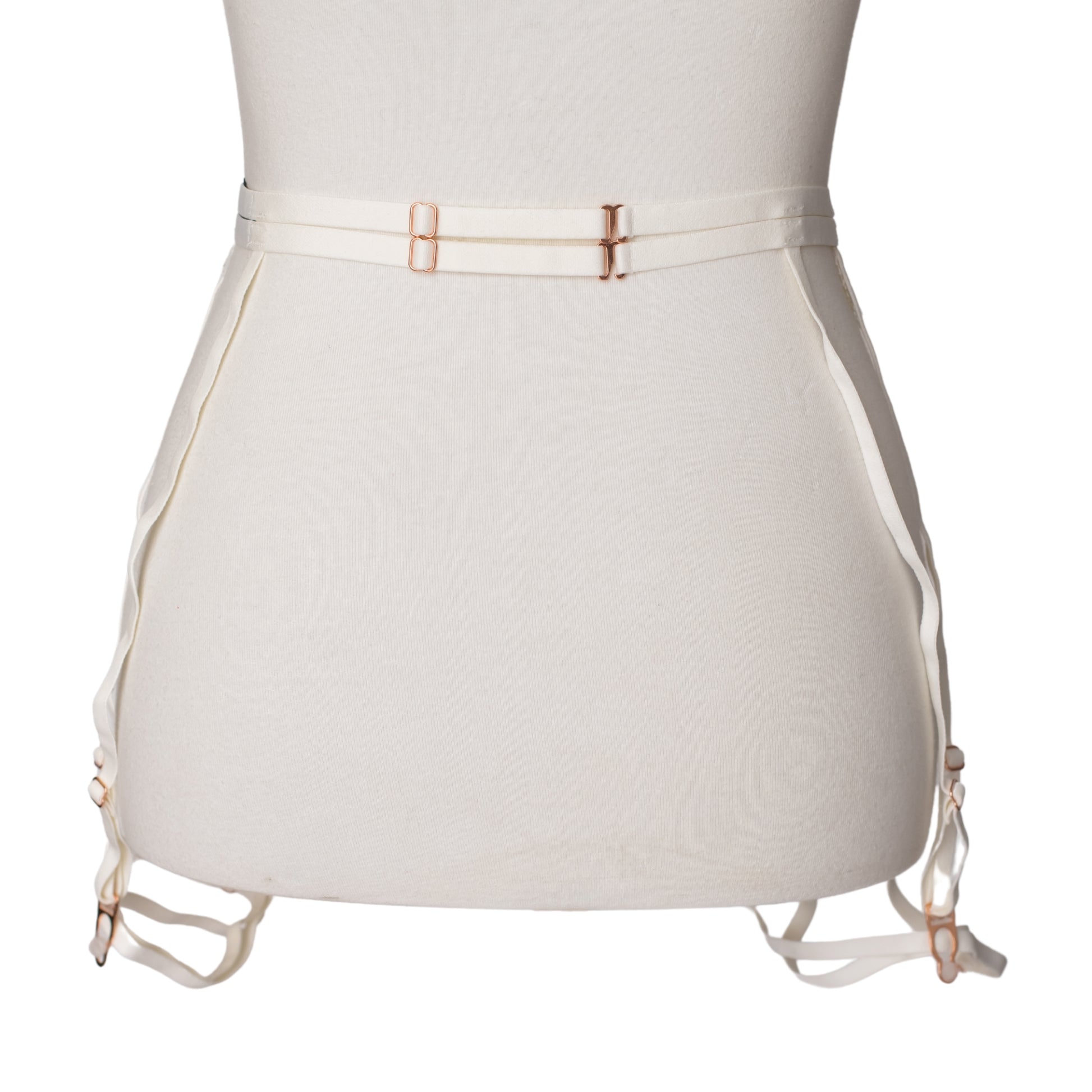 Back view of a white lace garter belt and leg garters with rose gold hardware